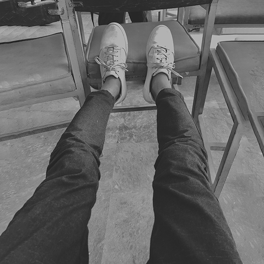 Black-and-white — feet up between chairs