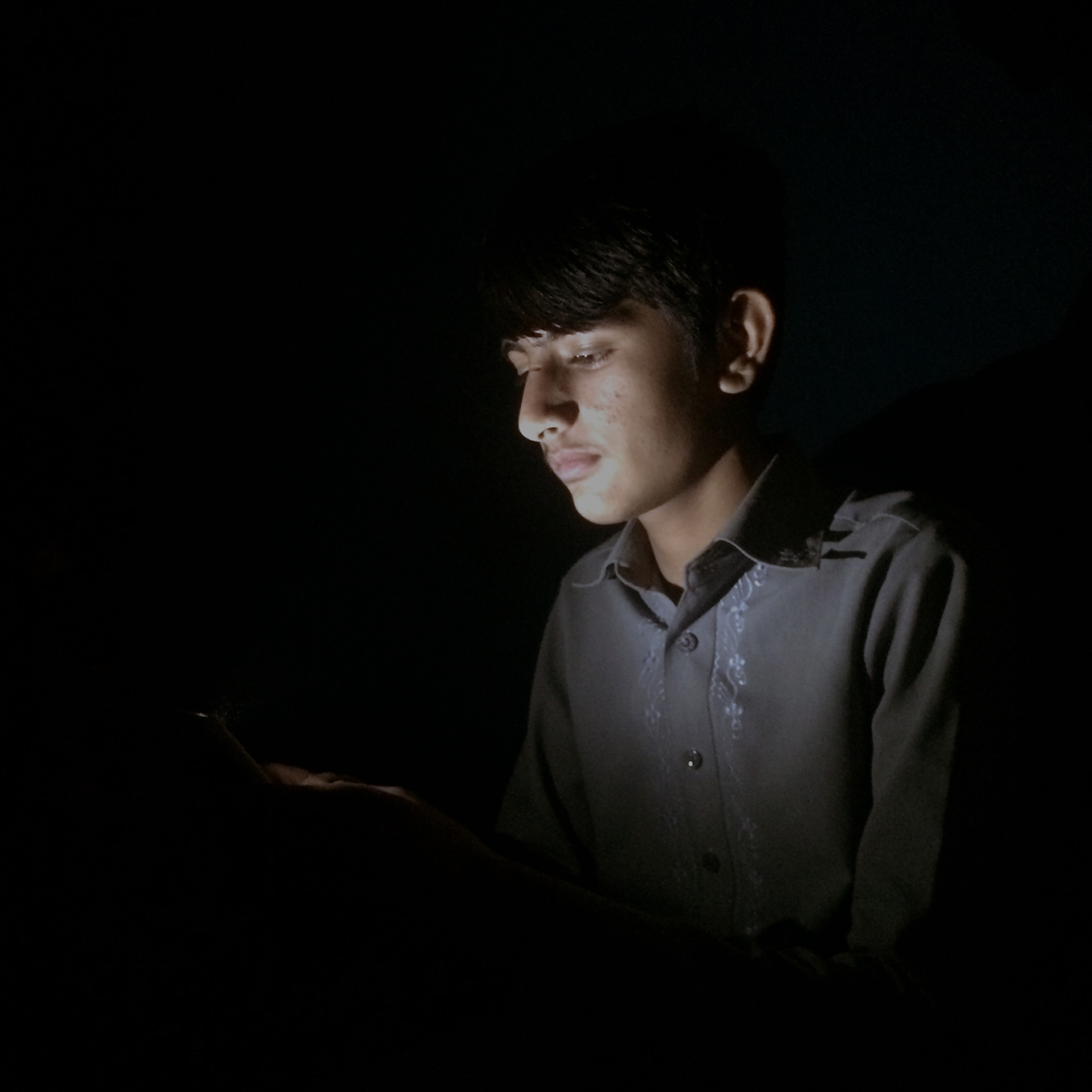 Portrait lit only by a phone screen